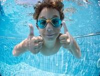 Image of a boy swimming underwater with his thumbs up