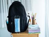 Image of school bag and face mask on a desk