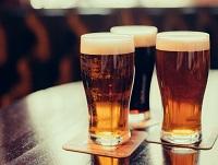 Image of three pints of beer on a wooden table Image of three pints of beer on a wooden table