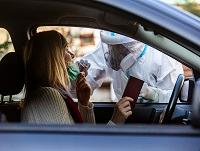 Image of woman sitting in a car have a swab sample taken