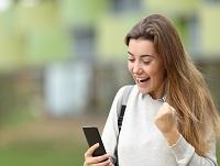 Image of excited learner reading news on smart phone