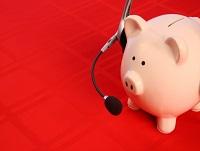 A piggy bank wearing a telephone headset