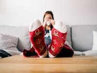 A woman looking warm and cosy with her Christmas socks on