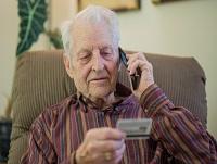 An elderly man making a credit card payment