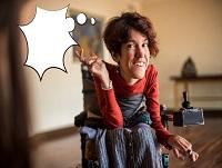 A woman in a motorised wheelchair pointing to her thought bubble