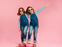 Image of twin girls on a skateboard
