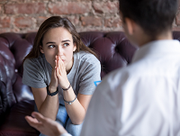 Image of a young girl looking worried talking to someone