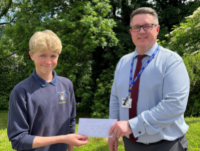 Image of a Headteacher presenting a prize to a pupil