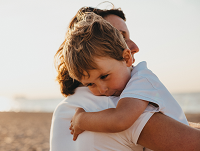 Image of a child cuddling an adult