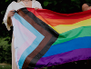 Image of two people holding a Pride flag