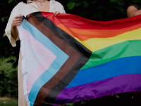 Image of two people holding a Pride flag