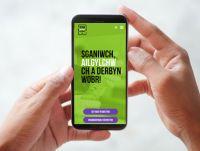 Image of hands holding a mobile phone with the Scan Recycle Reward app on the screen (cym)
