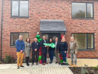 Image of people at the official opening of the council housing development that has been built on the former Red Dragon public house and Maesyrhandir Youth Centre in Newtown.