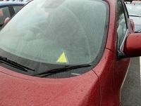 Image of a car with a yellow triangle sticker in the window