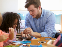 Image of a teacher and pupils working at a table