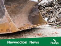 Image of a mechanical shovel with a pile of construction debris in the background