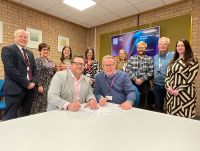 Matt Gofton of CIPD (front left) and Paul Bradshaw, Powys County Council’s Head of People (front right) signing the People Development Partnership agreement