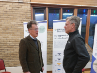 Image of Cllr Jake Berriman, Leader of Powys County Council, talking to David McKnight, from SVWMS, at the SVWMS drop-in session held at Bettws Village Hall.