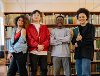 Four young people stood in a public library