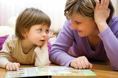 Image of a toddler reading with a woman