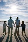Family holding hands on beach