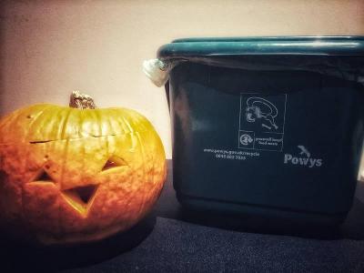 Image of a pumpkin next to a recycling bin