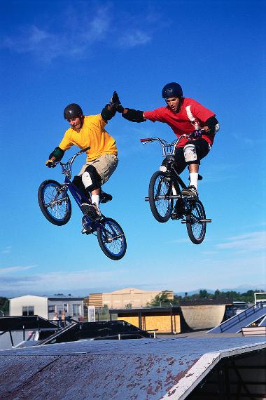 Image of two young people on bikes in a skate park
