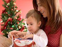 Image of a baby unwrapping a Christmas present with mum