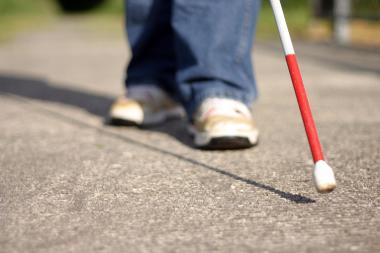 Image of a person walking with a white cane