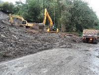 Image of diggers removing spoil after a landslide